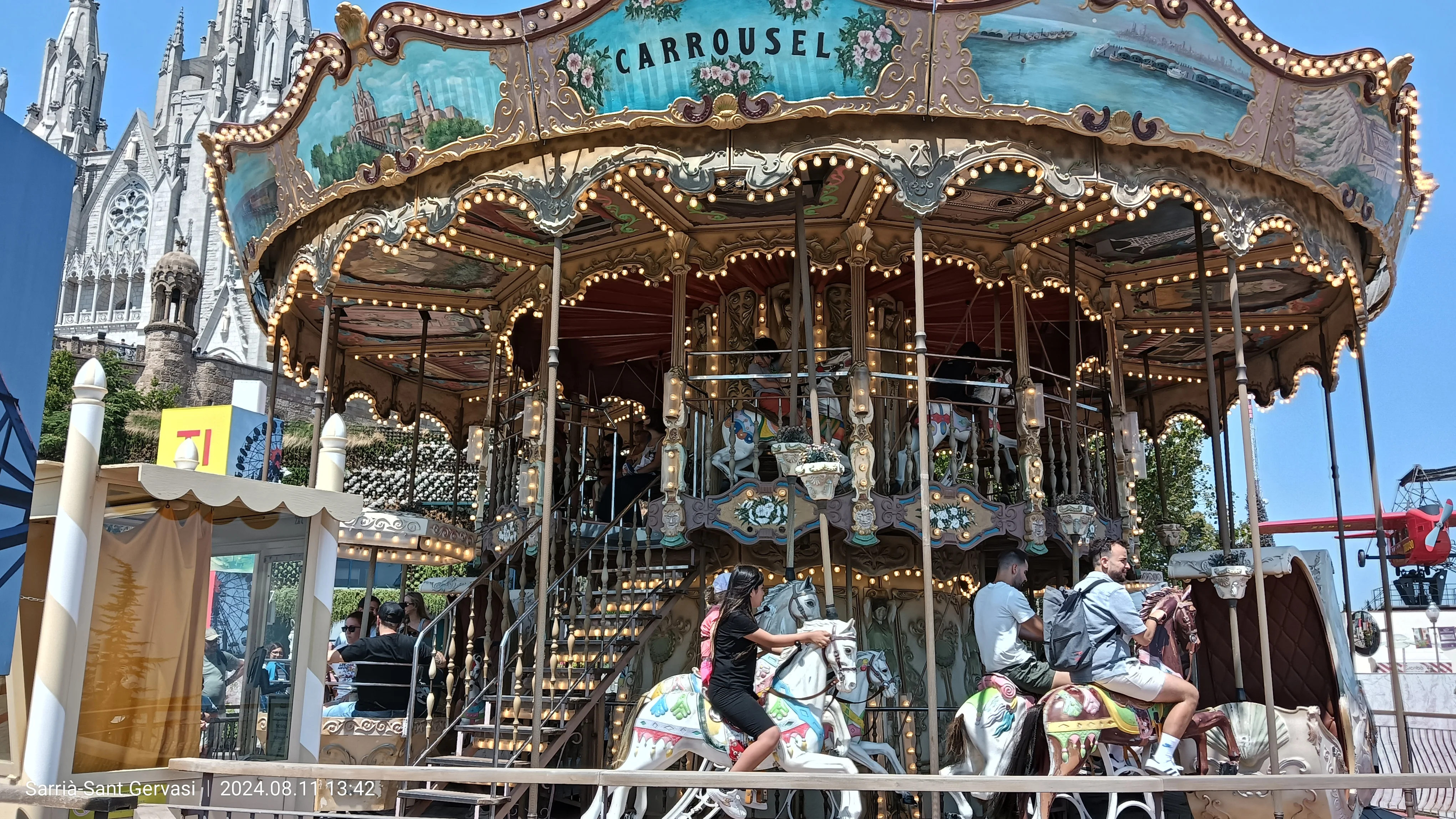 ティビダボ遊園地のクラシックなカルーセル（回転木馬）——背後にサクレ・コール教会がそびえる